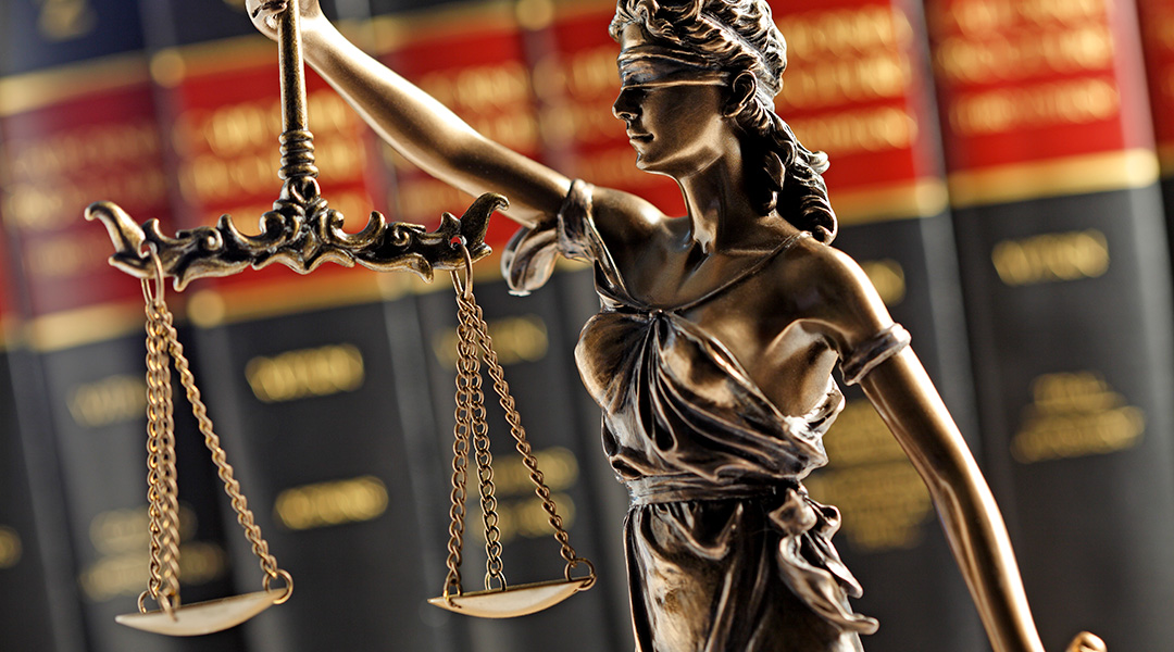 An small statue of a blindfolded woman holding scales, symbolizing justice