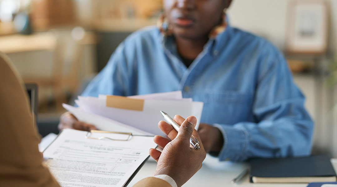 Two people discussing a variety of documents