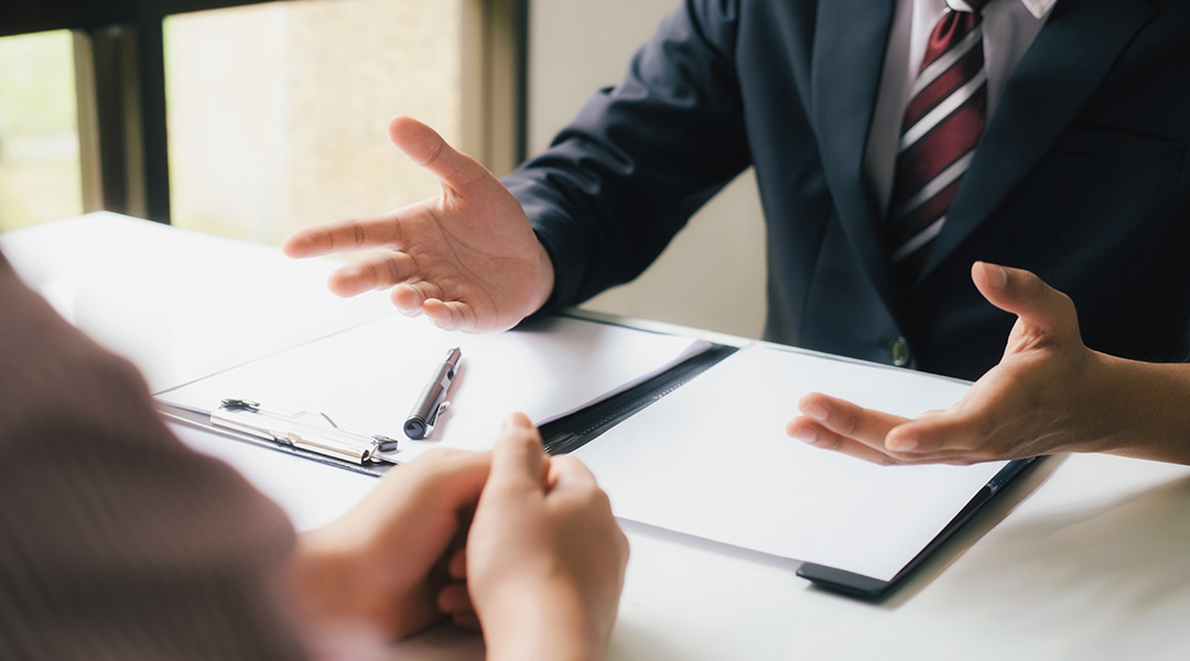 Two people at a table discussing legal documents